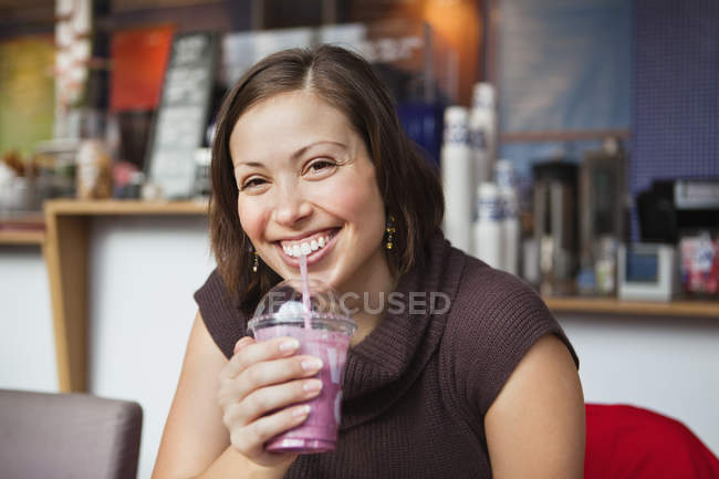 Mulher bebendo smoothie no café — Fotografia de Stock