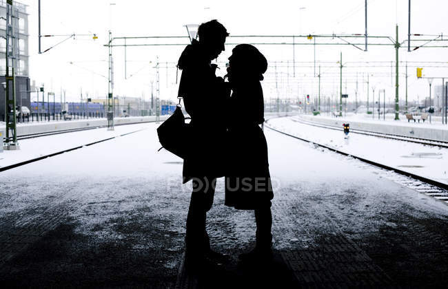 Пара силуэтов, стоящая на платформе — стоковое фото