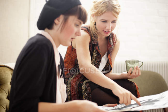 Blond painter pointing on painting with coworker — Stock Photo