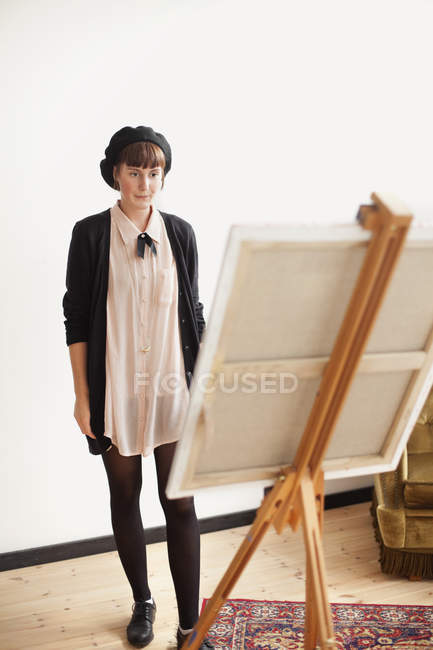 Pintor olhando para tela em estúdio — Fotografia de Stock