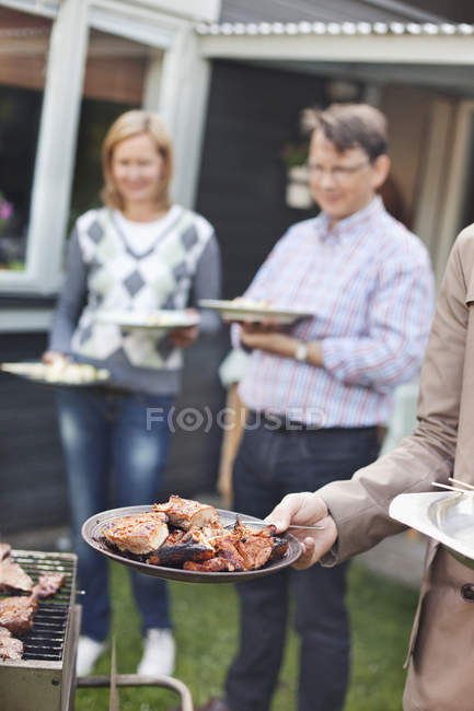 Man holding plate with meat — Stock Photo