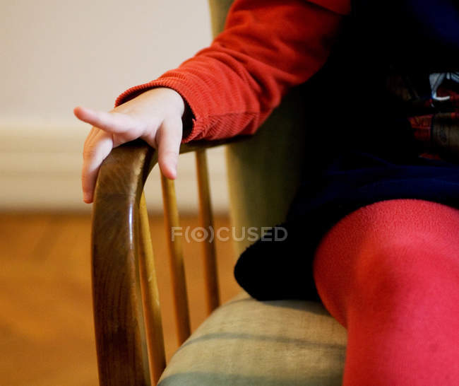 Ragazza seduta sulla sedia a casa — Foto stock