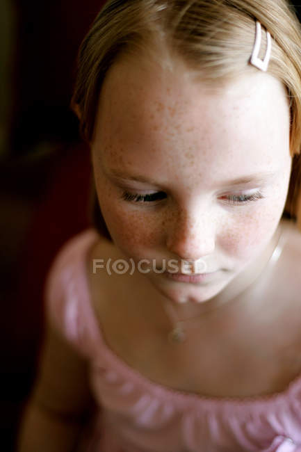 Retrato de chica triste con pecas mirando hacia abajo - foto de stock