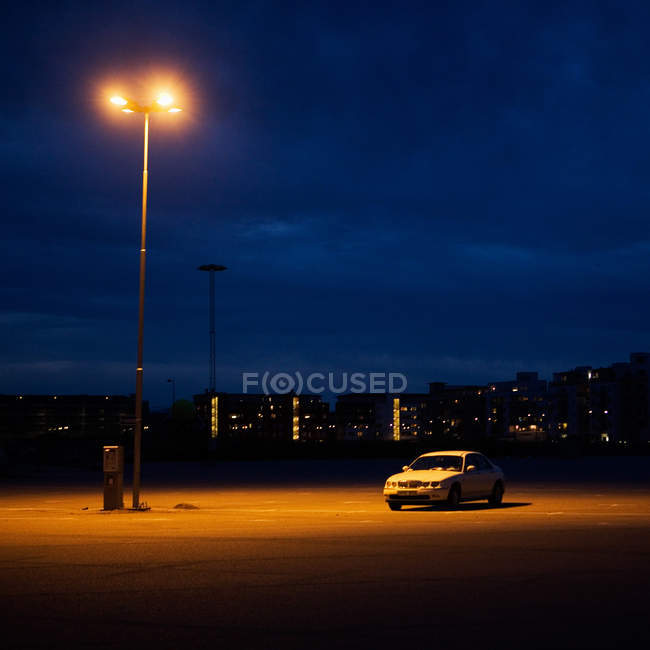 Автомобиль на освещенной городской улице — стоковое фото