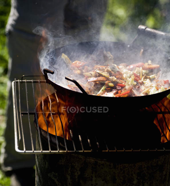 Person cooking food outdoors — Stock Photo