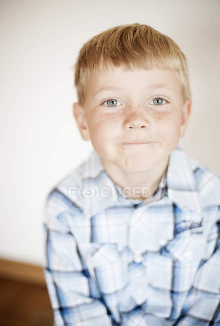 Portrait de garçon blond contre le mur à la maison — Photo de stock