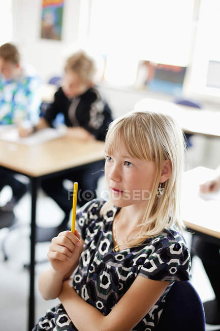 Mädchen sitzt mit Bleistift — Stockfoto