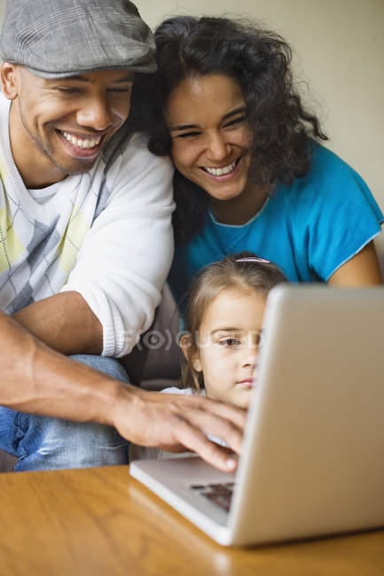Семья с ноутбуком дома — стоковое фото
