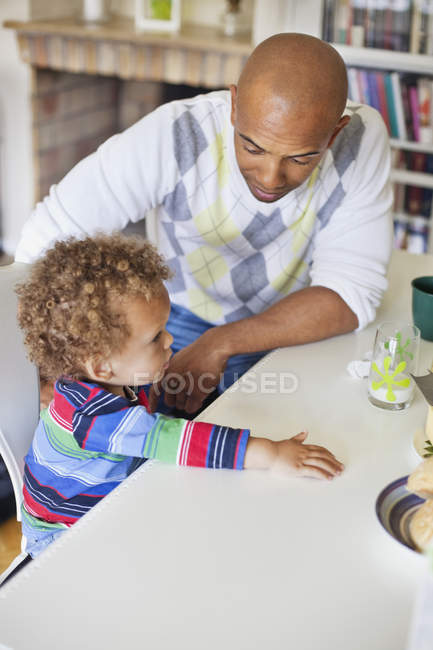 Père assis avec son fils à table — Photo de stock