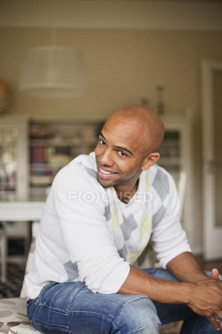 Homme assis sur des meubles dans le salon — Photo de stock