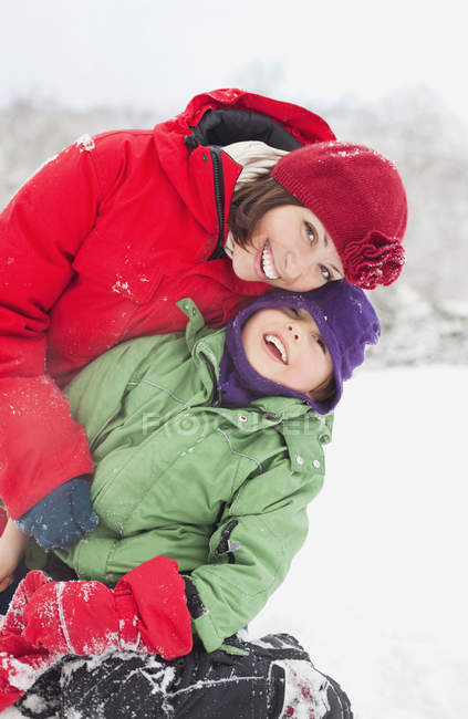 Mãe com filho se divertindo na neve — Fotografia de Stock