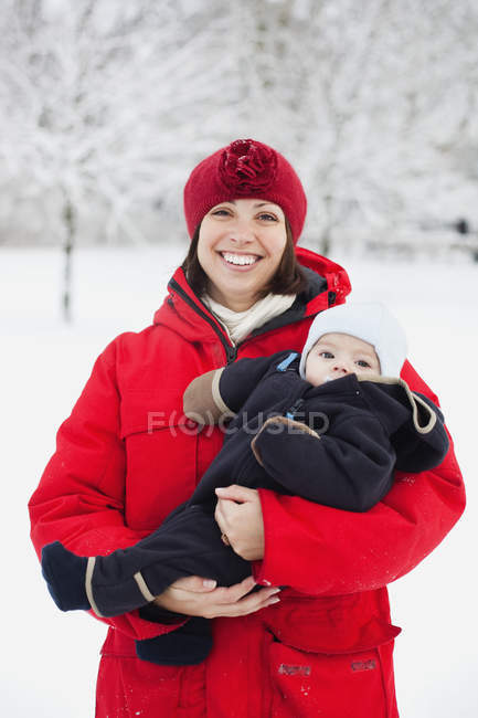 Donna felice portando bambino ragazzo — Foto stock