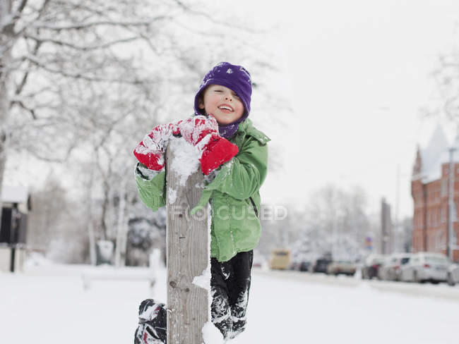 Мальчик, стоящий на коленях в снегу — стоковое фото