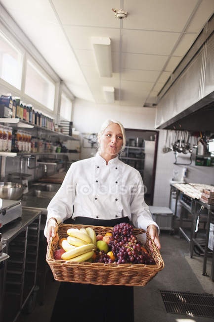 Koch trägt Korb mit Früchten — Stockfoto