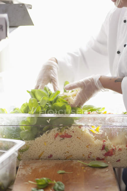 Chef mélangeant légumes en récipient — Photo de stock