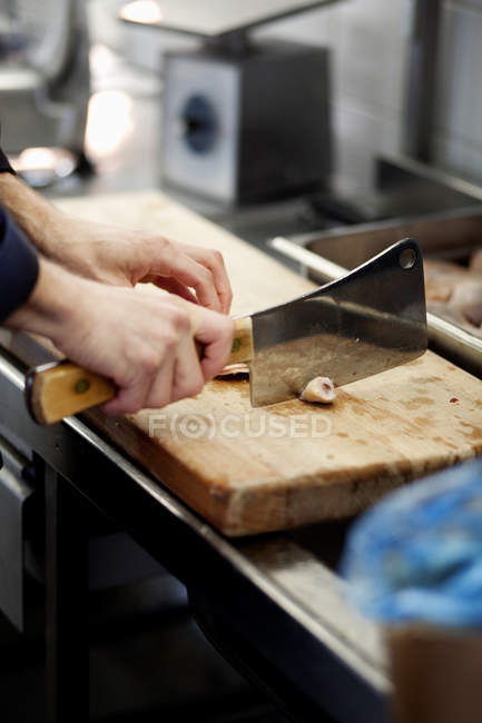 Шеф-кухар подрібнює м'ясо на обробній дошці — стокове фото