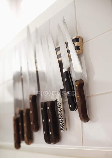 Divers couteaux sur mur carrelé — Photo de stock