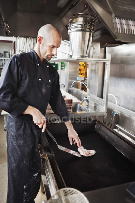 Chef cooking meat in restaurant kitchen — Stock Photo