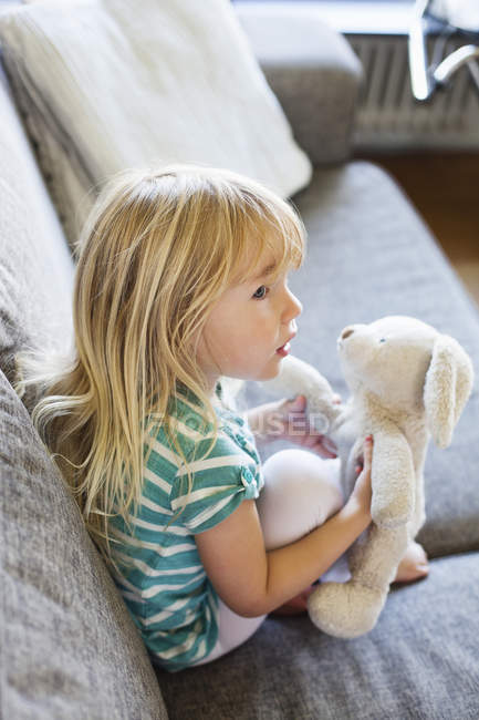 Mignonne fille assise avec jouet — Photo de stock