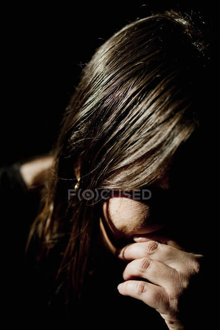 Mulher triste contra o preto — Fotografia de Stock