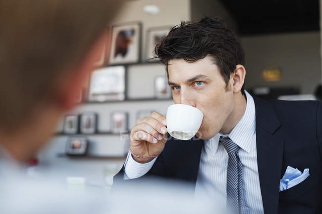 Businessman drinking coffee with coworker — Stock Photo