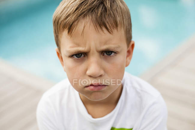 Angry boy against swimming pool — Stock Photo
