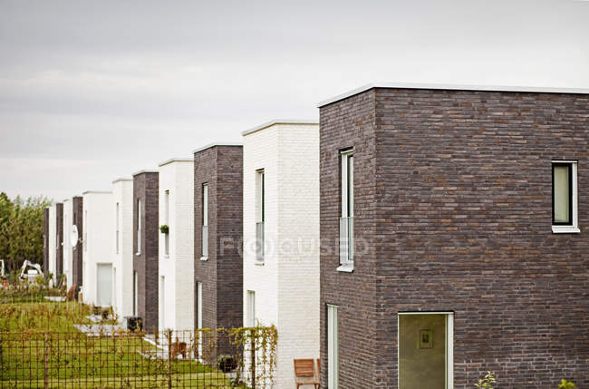 Buildings by field against sky — Stock Photo