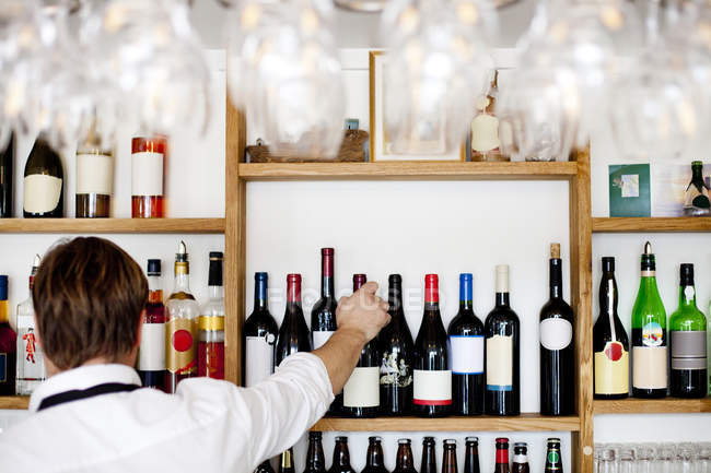 Чоловічий шеф-кухар організовує пляшки вина — стокове фото