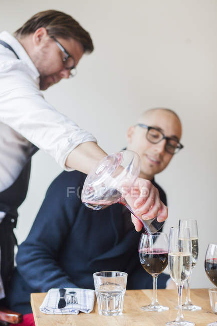 Chef servant du vin rouge au client — Photo de stock