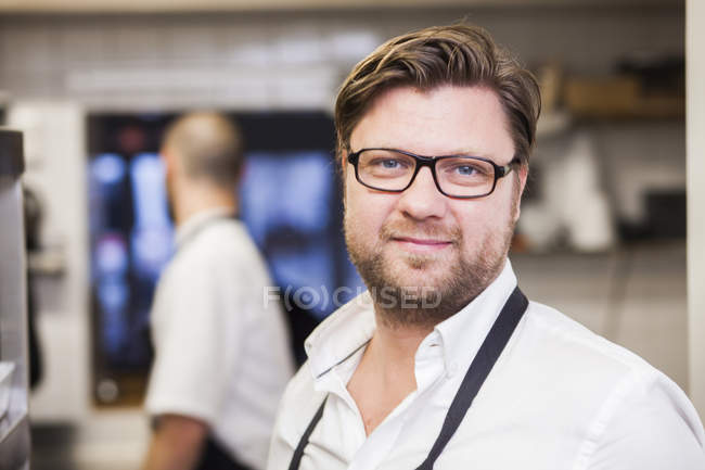 Chef at commercial kitchen with colleague — Stock Photo