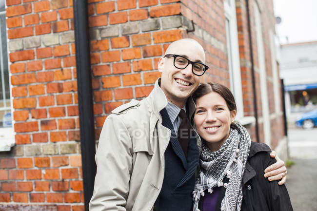 Couple debout contre le bâtiment — Photo de stock