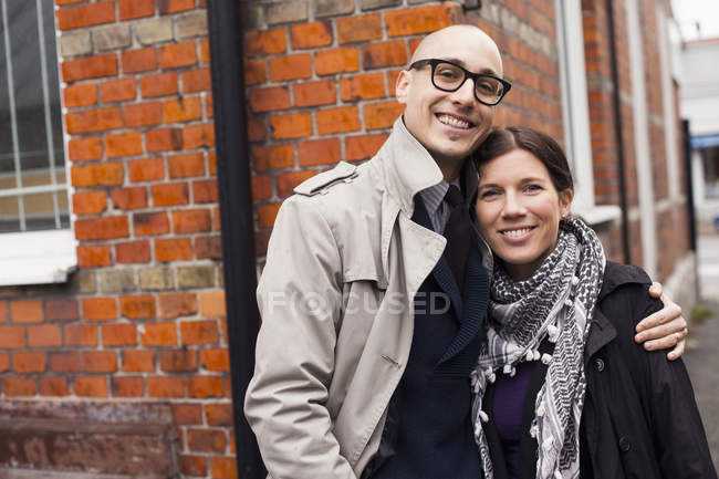 Couple standing against brick wall — Stock Photo