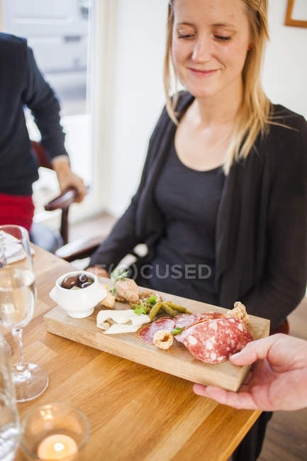 Waiter serving food to woman — Stock Photo