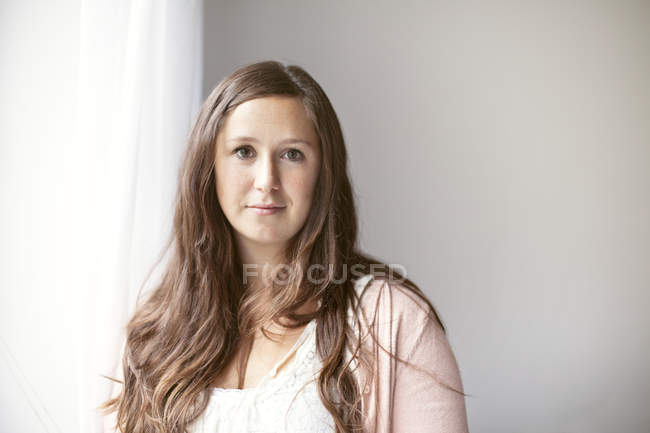 Beautiful woman standing against wall — Stock Photo