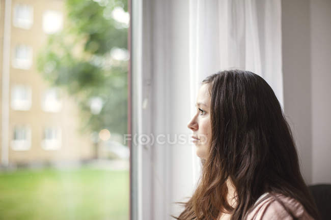 Жінка проти вікно — стокове фото