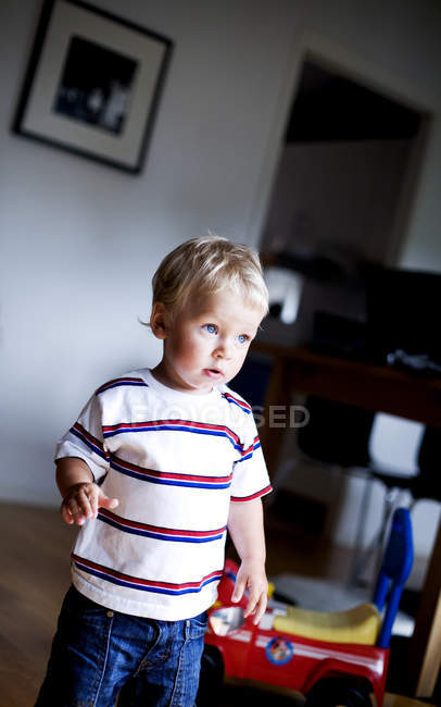 Kleiner Junge schaut weg, während er im Zimmer steht — Stockfoto