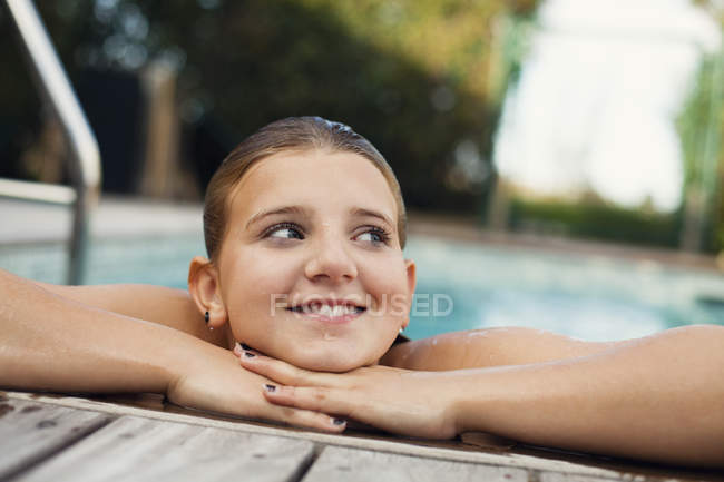 Fille penché au bord de la piscine — Photo de stock