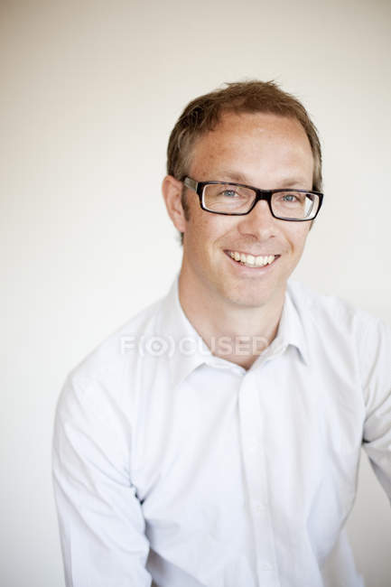 Portrait of mature man against white wall at home — Stock Photo