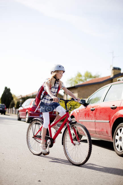 Девушка в шлеме на велосипеде по улице — стоковое фото