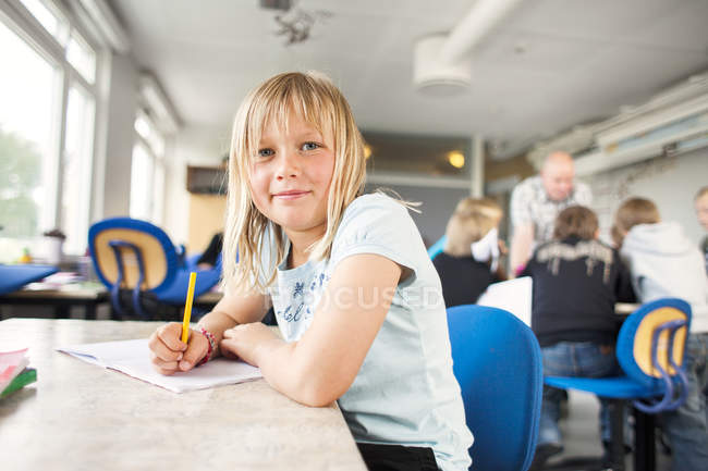 Portrait d'écriture écolière mignonne — Photo de stock