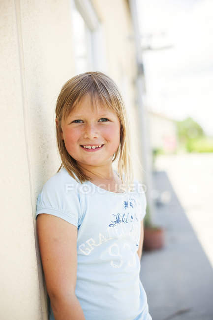 Happy schoolgirl standing at playground — Stock Photo