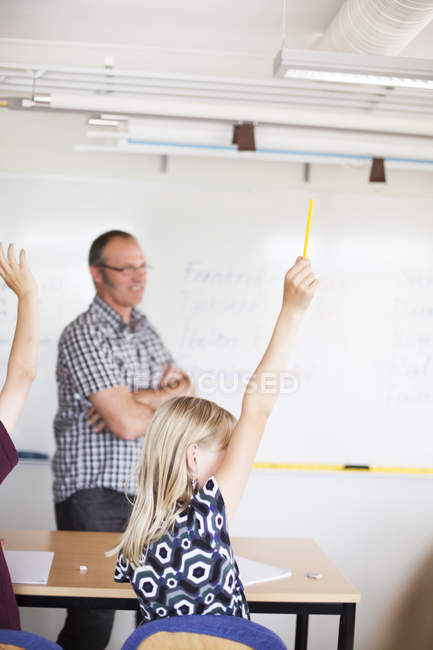Школьница, поднимающая руку — стоковое фото
