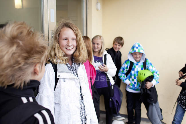 Amigos felizes em pé no prédio da escola — Fotografia de Stock