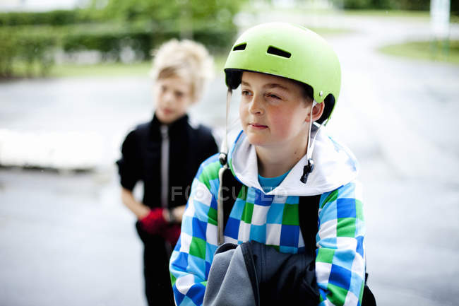 Menino usando capacete com amigo — Fotografia de Stock