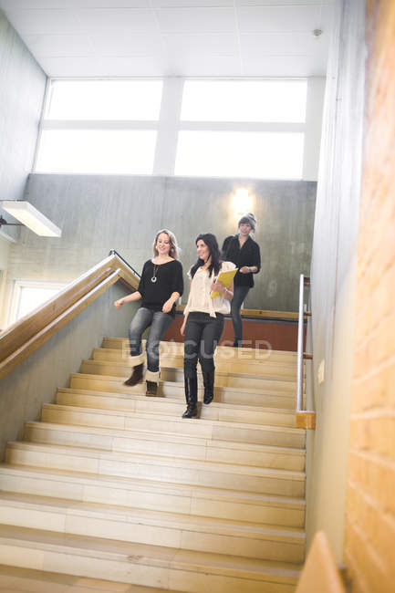 Низький кут зору студенток-жінок, що рухаються вниз по сходах у старшій школі — стокове фото