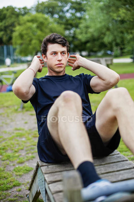 Handsome man practicing sit-ups — Stock Photo