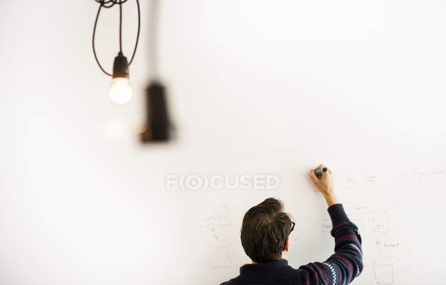 Geschäftsmann schreibt auf Whiteboard — Stockfoto