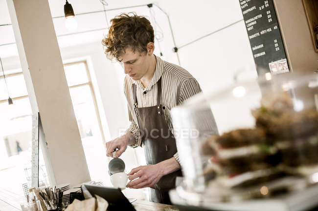 Young barista making cappuccino — Stock Photo
