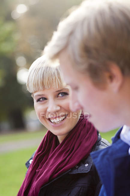 Mulher feliz olhando para amigo masculino — Fotografia de Stock