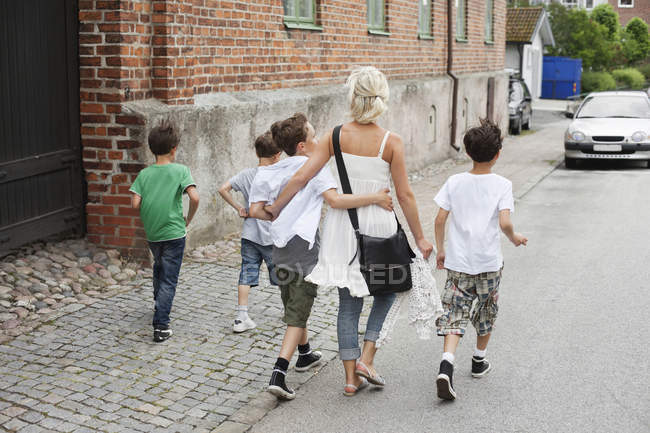 Mulher andando com filhos — Fotografia de Stock